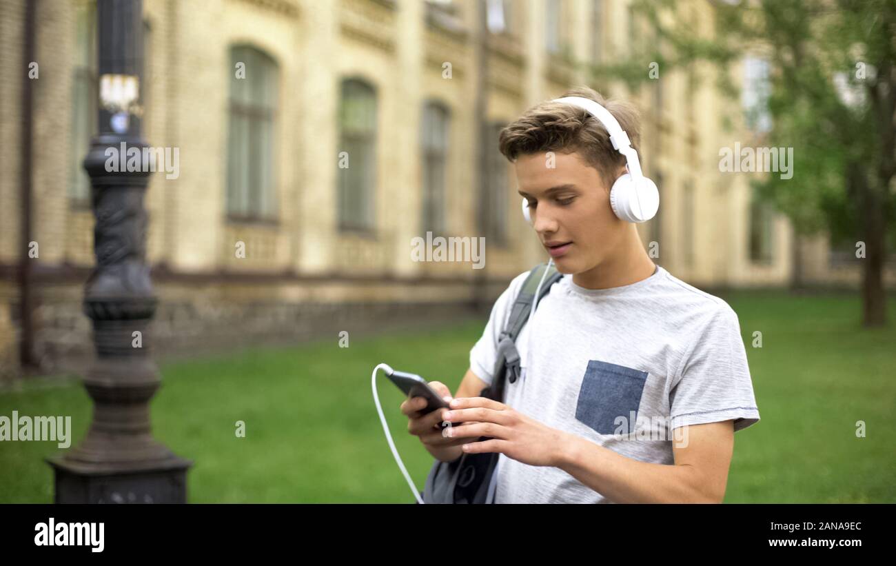 Adolescente en los auriculares para escuchar música, audio app descargar playlist Foto de stock