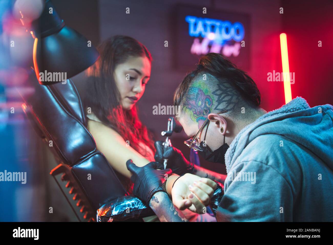 Mujer Joven Recibiendo Tatuajes En Salón De Belleza Con Trabajo Tatuador Foto de stock