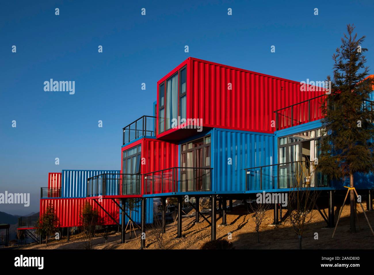 Un contenedor de coloridos, un hotel compuesto de varios contenedores y  situado en la altura de 2200 metros sobre el nivel del mar, se levanta al  amanecer en Y Fotografía de stock -