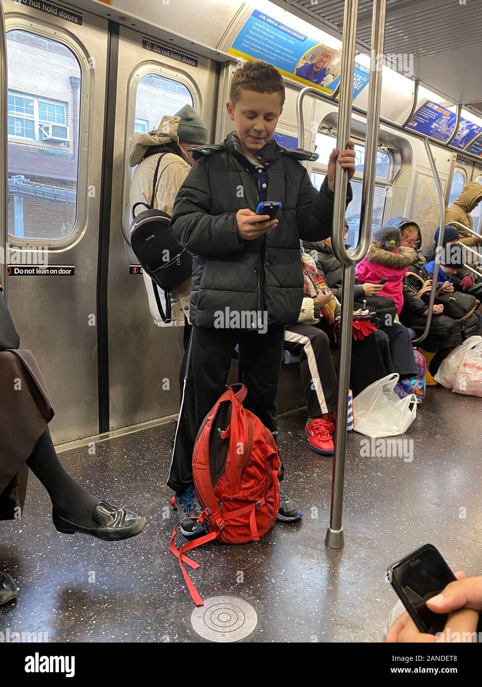 Las personas están constantemente en sus teléfonos celulares cuando viajan  los trenes del metro en la Ciudad de Nueva York Fotografía de stock - Alamy