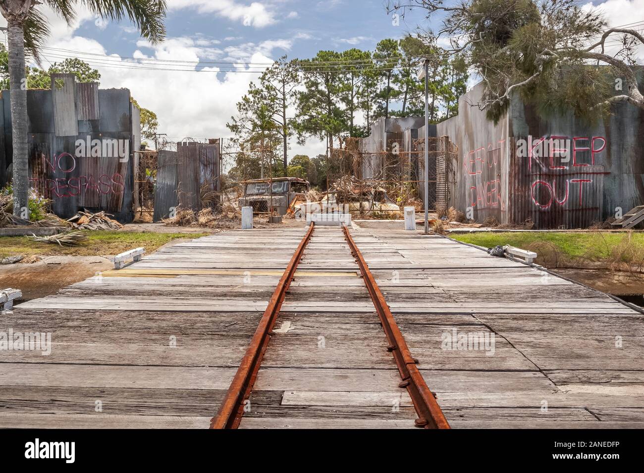 Gold Coast, Australia-Nov 22,2010: un pequeño rusty ferrocarril privado en suelo de madera, en el patio o demolición junkyard, rusty coches y camiones cerca de un metal y Foto de stock