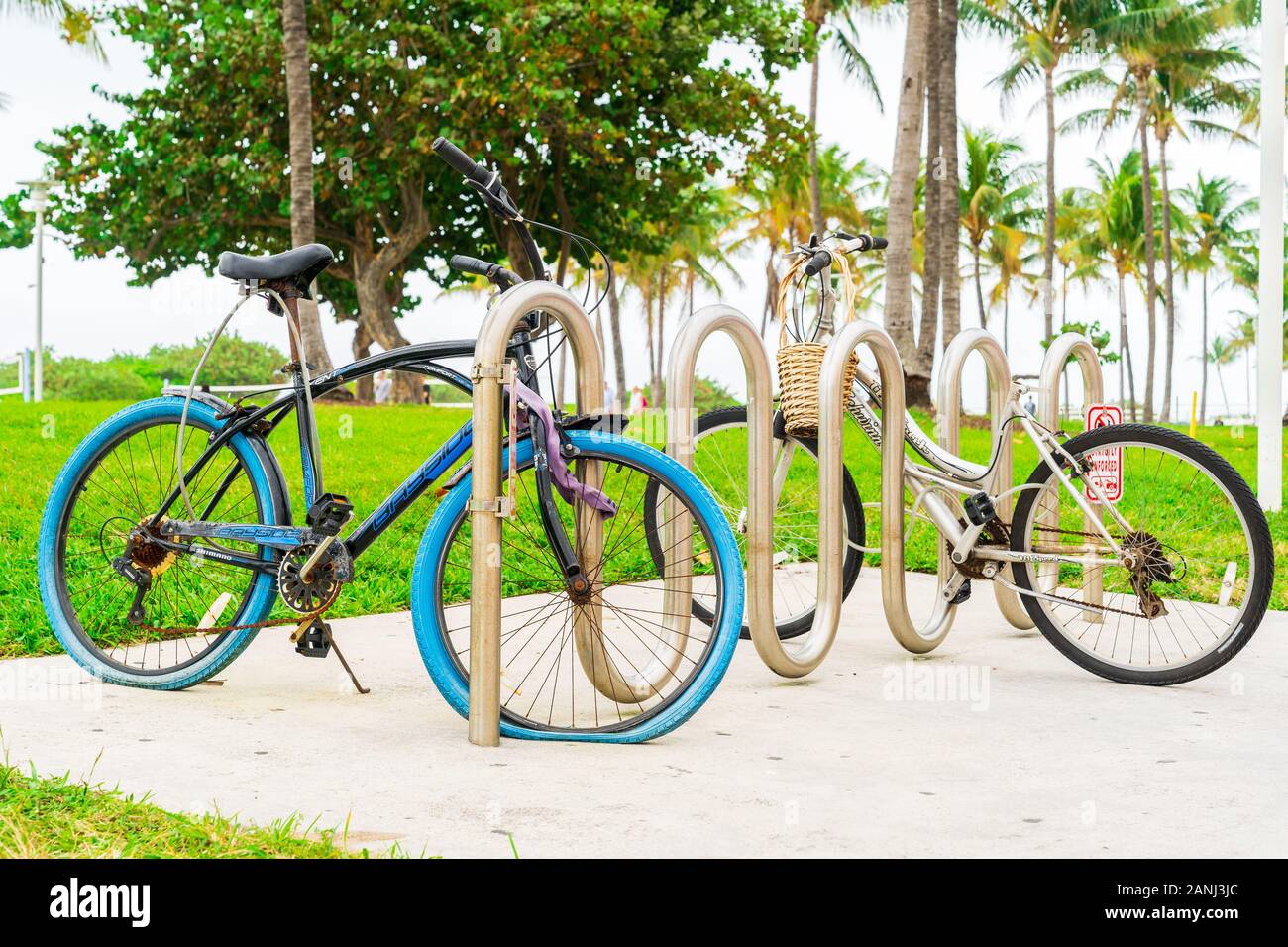 Miami, Florida - 30 De Diciembre De 2019: Dos Bicicletas Estacionadas Una Con Un Neumático Plano En Ocean Drive, Miami, Florida. Foto de stock