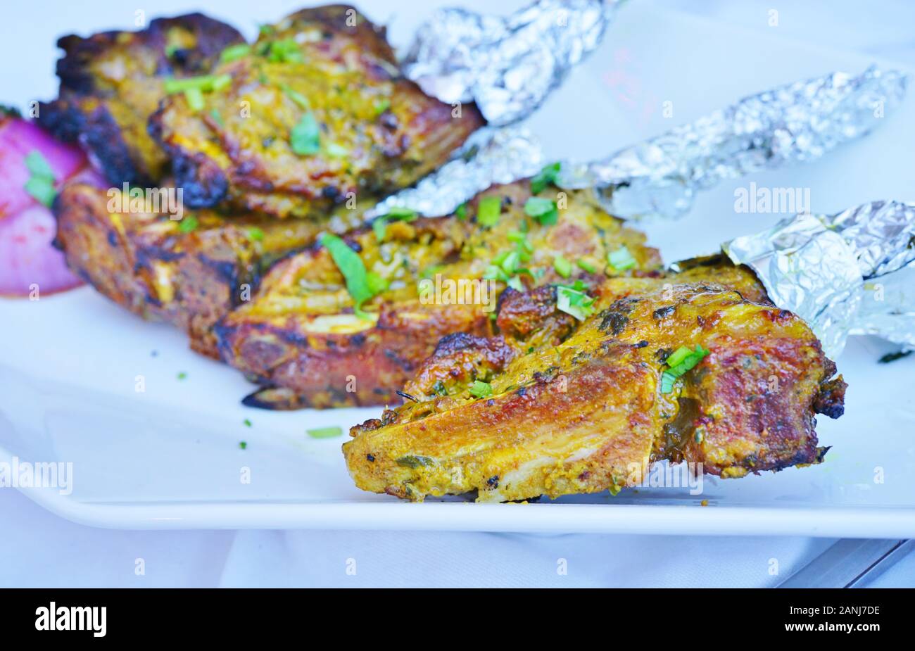 Una fuente de chuletas de cordero a la parrilla envuelta en papel de  aluminio en un restaurante indio Fotografía de stock - Alamy