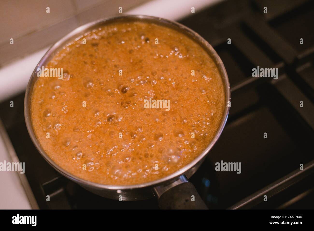 Hervir y hervir el agua y el azúcar en una sartén en la estufa. Caramelo  salado cocinar en casa. La receta casera de caramelo y azúcar quemado  Fotografía de stock - Alamy