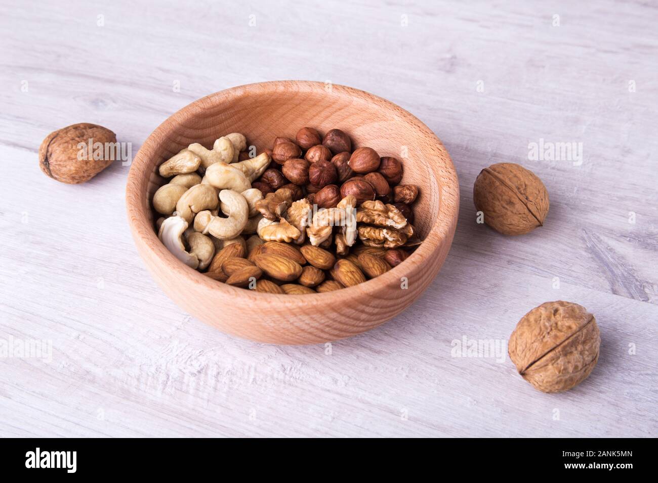 Cuchara de madera con surtido de frutos secos sobre mesa de madera. Primer plano. Foto de stock