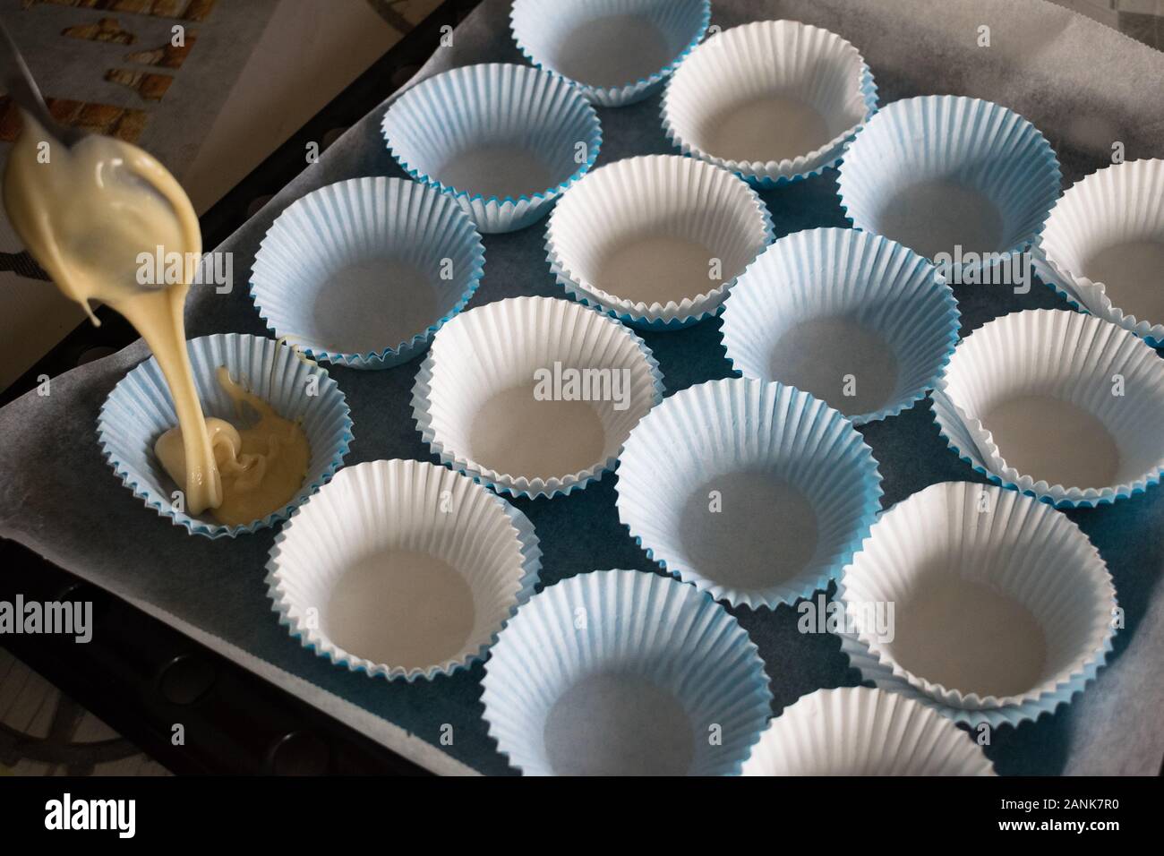 Delicioso Presidente Conjugado Llenar con la masa los moldes de papel para hacer muffins caseros  Fotografía de stock - Alamy
