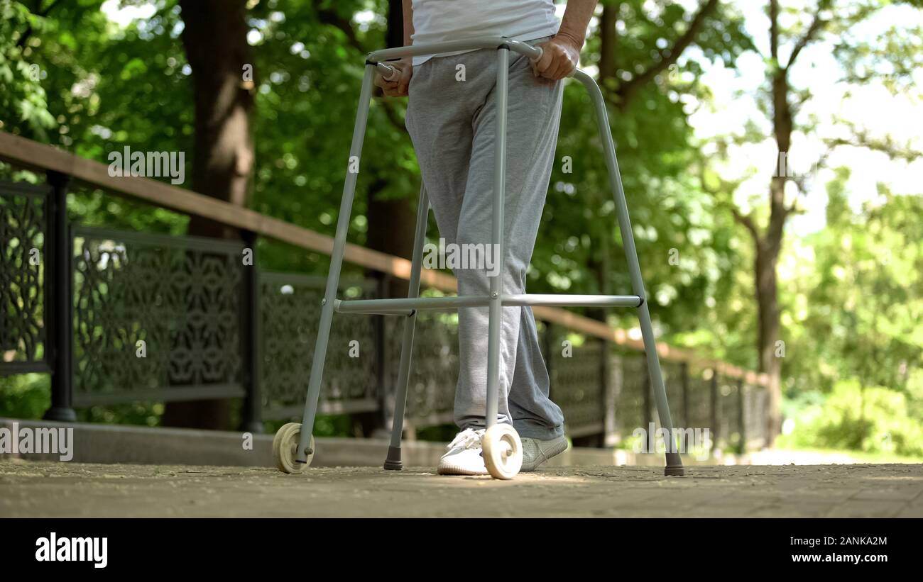 Las piernas del paciente moviendo con ayuda de caminar frame en el