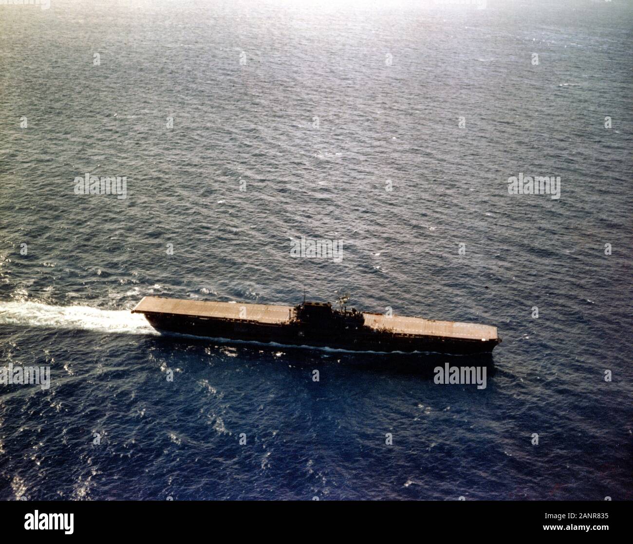 USS Enterprise (CV-6) que operan en el Pacífico, alrededor de finales de junio de 1941. Ella se está convirtiendo en el viento para recuperar los aviones. Nota de su cubierta de vuelo de madera natural manchas oscuras y medir un esquema de pintura de camuflaje. La cubierta de vuelo estaba manchado de azul en julio de 1941, durante experimentos de camuflaje que le dio un único patrón de banda de cubierta. Foto de stock
