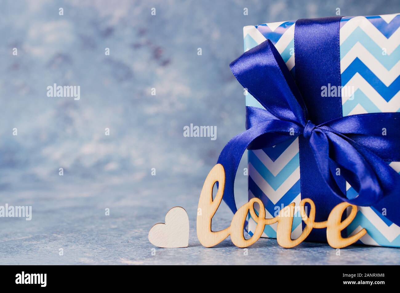 Caja de regalo de amor y la inscripción sobre fondo azul. Concepto de  regalos para los hombres. Tarjeta de felicitación para el Día de San  Valentín, cumpleaños o el Día del Padre