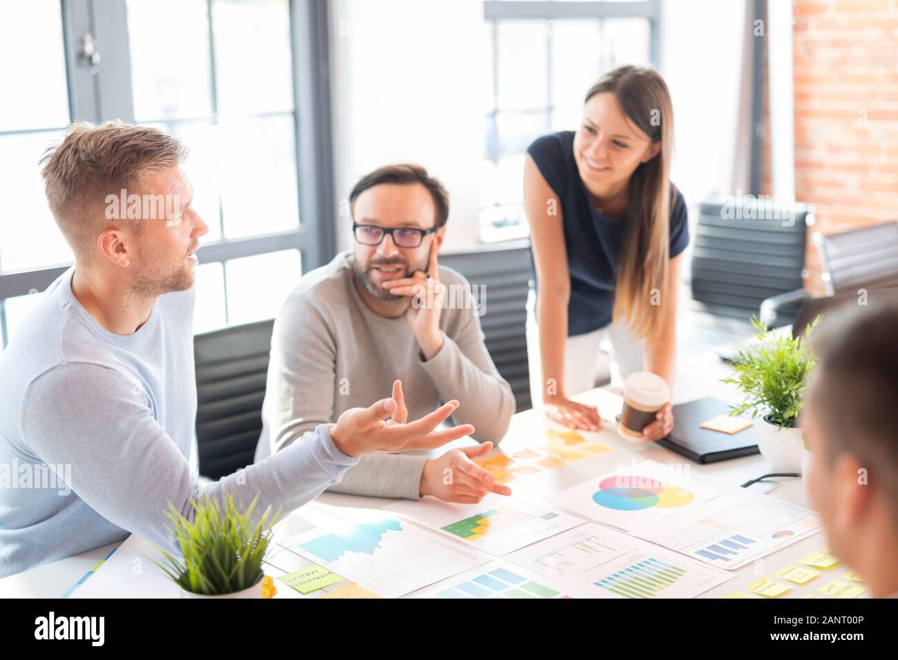 Los empresarios reunidos en la oficina y utilizar post-it Notes para compartir la idea. Concepto de lluvia de ideas. Nota sobre la pared de vidrio. Foto de stock