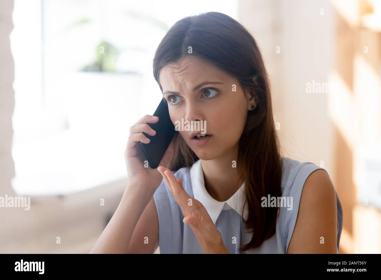 La empresaria hablando por teléfono con el cliente insatisfecho resolver problemas lejanamente Foto de stock