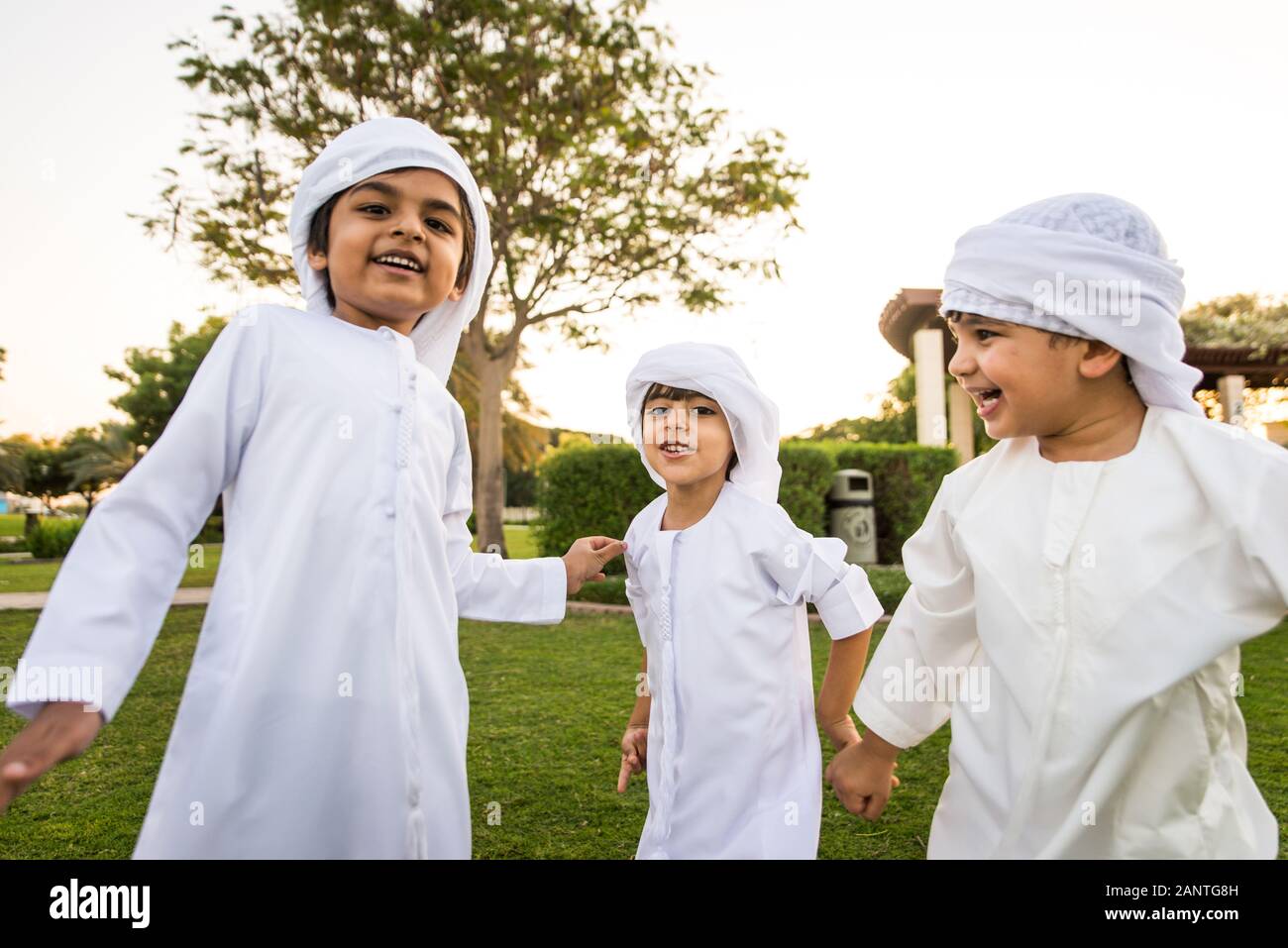 Grupo de medio oriente los niños vestidos de blanco kandora jugando en un parque en - Feliz grupo de amigos a al aire libre los Emiratos Árabes Unidos Fotografía