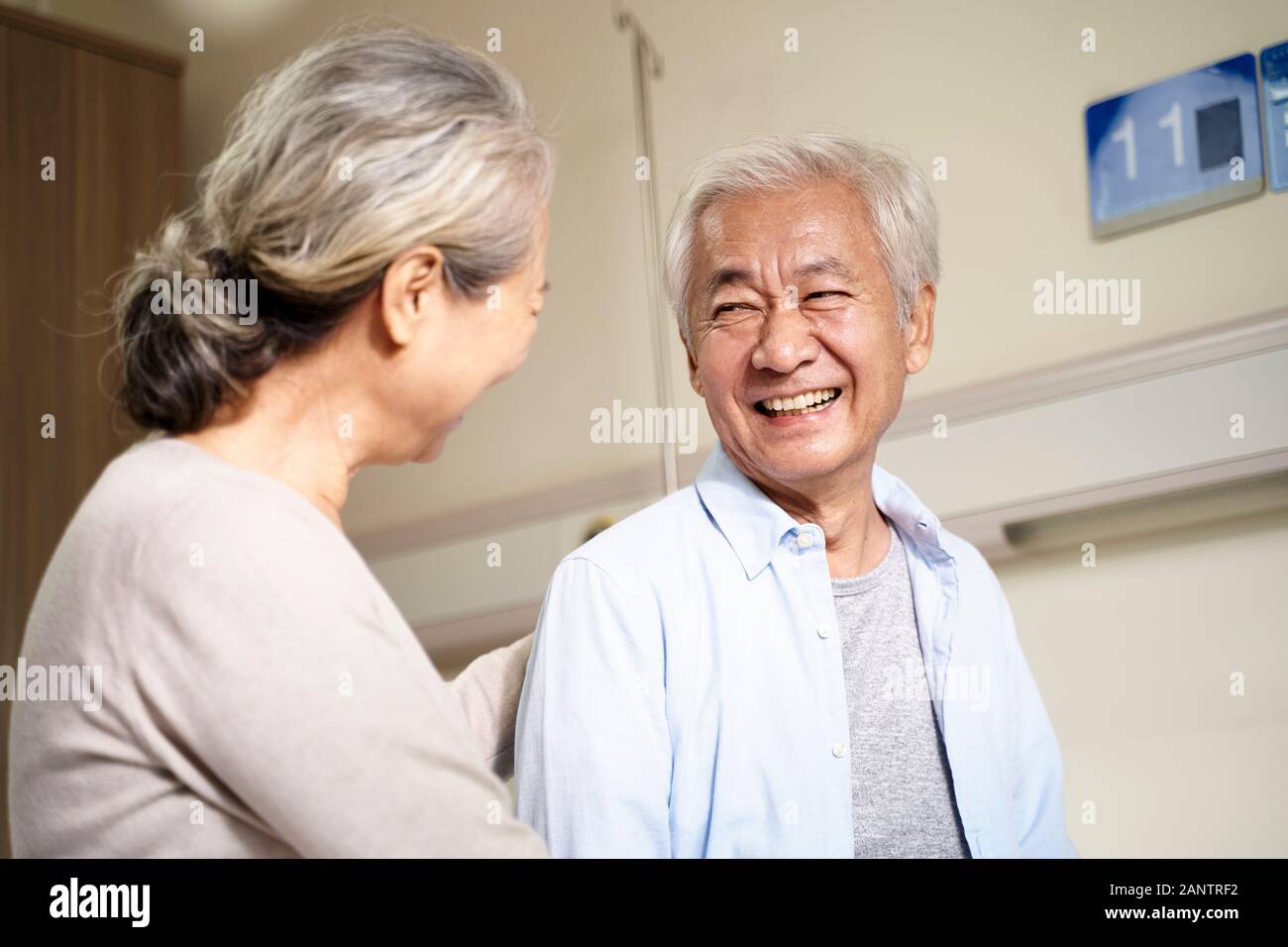 Feliz pareja senior asiáticos hablando en la sala de hospital Foto de stock