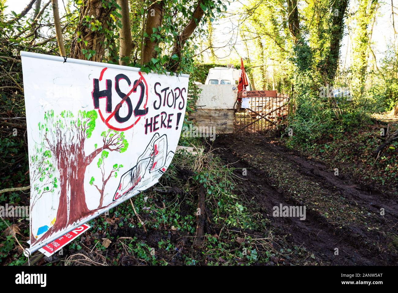 Wendover, Buckinghamshire, Reino Unido.El 18 de enero de 2020. Decididos activistas opuestos a HS2 establecido recientemente la resistencia activa Wendover campamento en el bosque al sur de Wendover adyacente a la A413. El campamento está en la ruta del proyecto HS2 línea de ferrocarril donde cruzaría el A413. El Campamento de la resistencia activa Wendover tiene intención de ocupar su sitio en la medida de lo posible, oponerse a la construcción de la línea ferroviaria de HS2. La entrada al campamento, pancartas, advierten que el motorista HS2 línea férrea cruzará aquí, y un banner indica HS2 se detendrá aquí. Crédito: Stephen Bell/Alamy Foto de stock