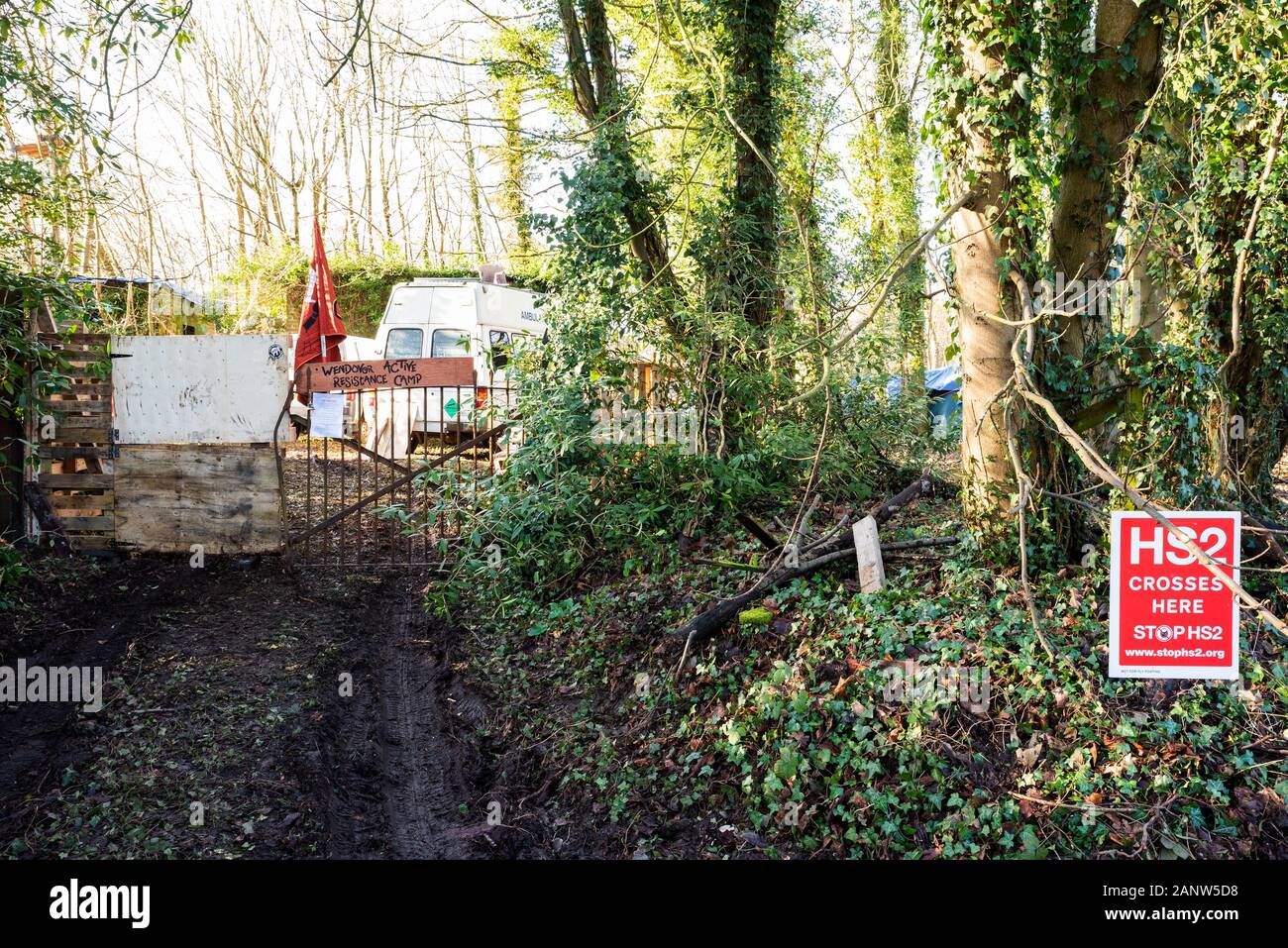 Wendover, Buckinghamshire, Reino Unido.El 18 de enero de 2020. Decididos activistas opuestos a HS2 establecido recientemente la resistencia activa Wendover campamento en el bosque al sur de Wendover adyacente a la A413. El campamento está en la ruta del proyecto HS2 línea de ferrocarril donde cruzaría el A413. El Campamento de la resistencia activa Wendover tiene intención de ocupar su sitio en la medida de lo posible, oponerse a la construcción de la línea ferroviaria de HS2. La entrada al campamento, pancartas, advierten que el motorista HS2 línea de ferrocarril se cruzan aquí. Crédito: Stephen Bell/Alamy Foto de stock