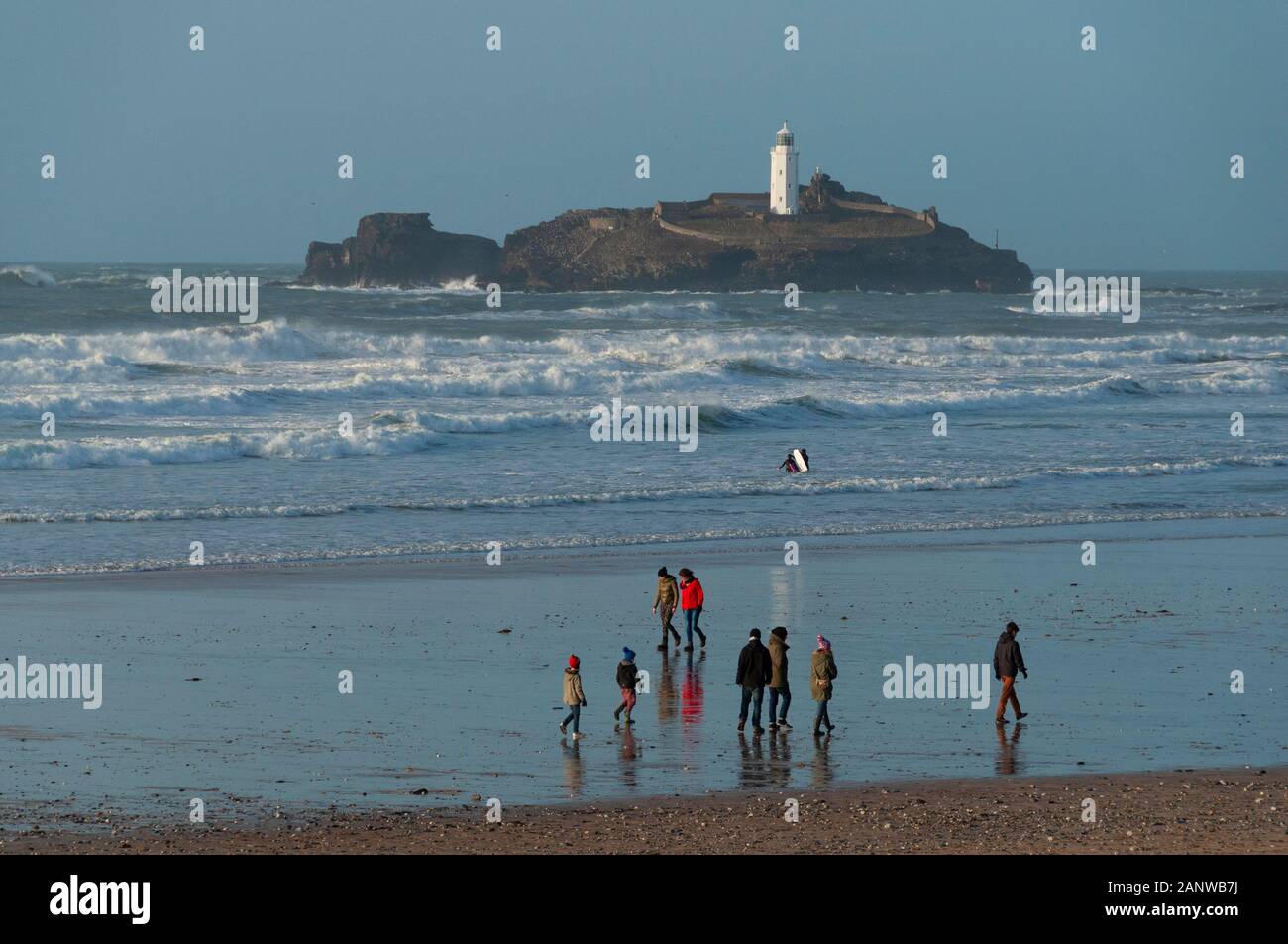 La gente en la playa enfrente de Godrevy isla situada en la costa norte de Cornwall Inglaterra Foto de stock