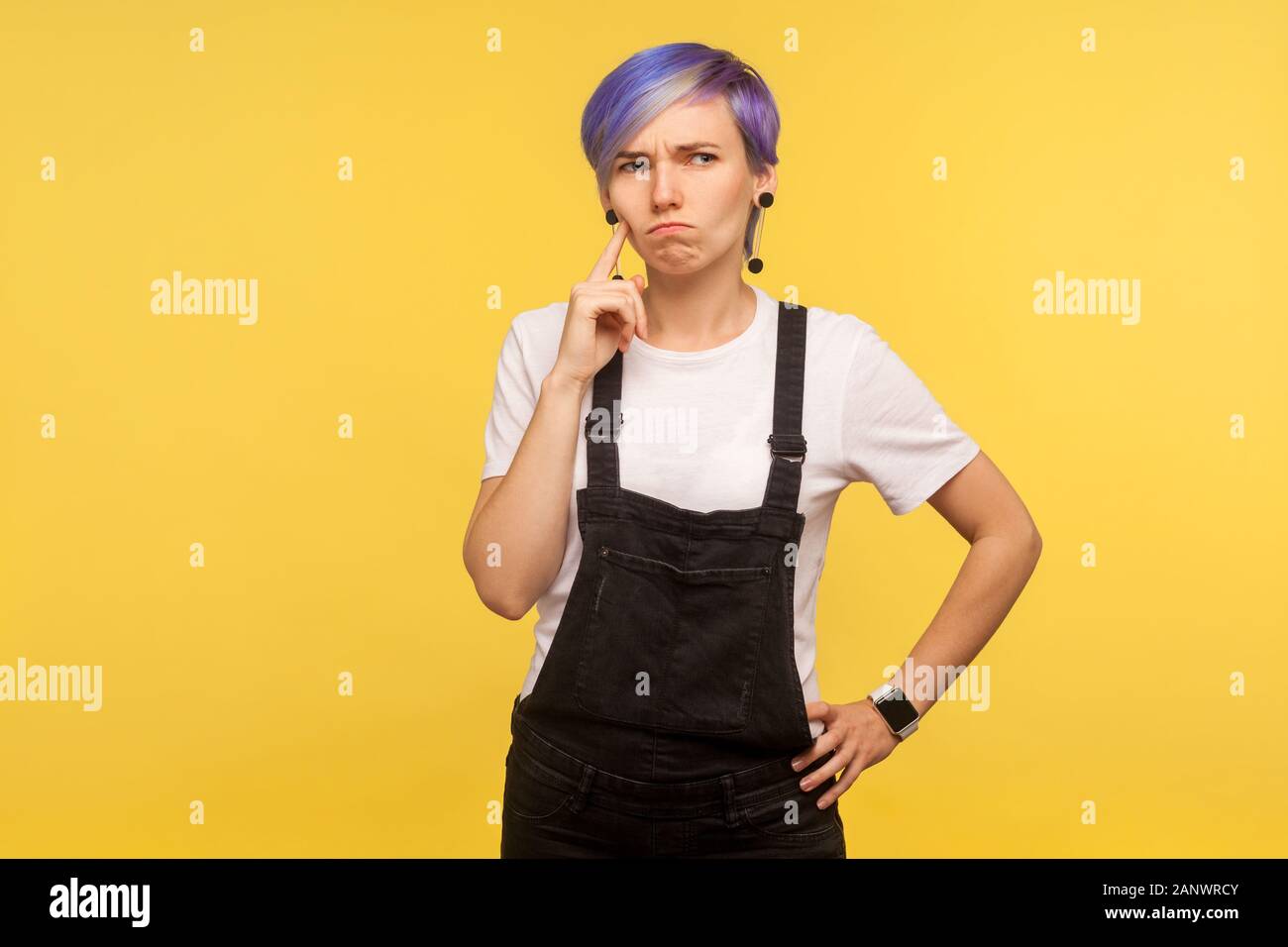 Retrato De Pensive Hipster Mujer Con Violeta Tenido De Pelo Corto En Denim Monos Mirando Confundida Habiendo Dudas De Como Resolver Problemas El Pensamiento Intenso Fotografia De Stock Alamy