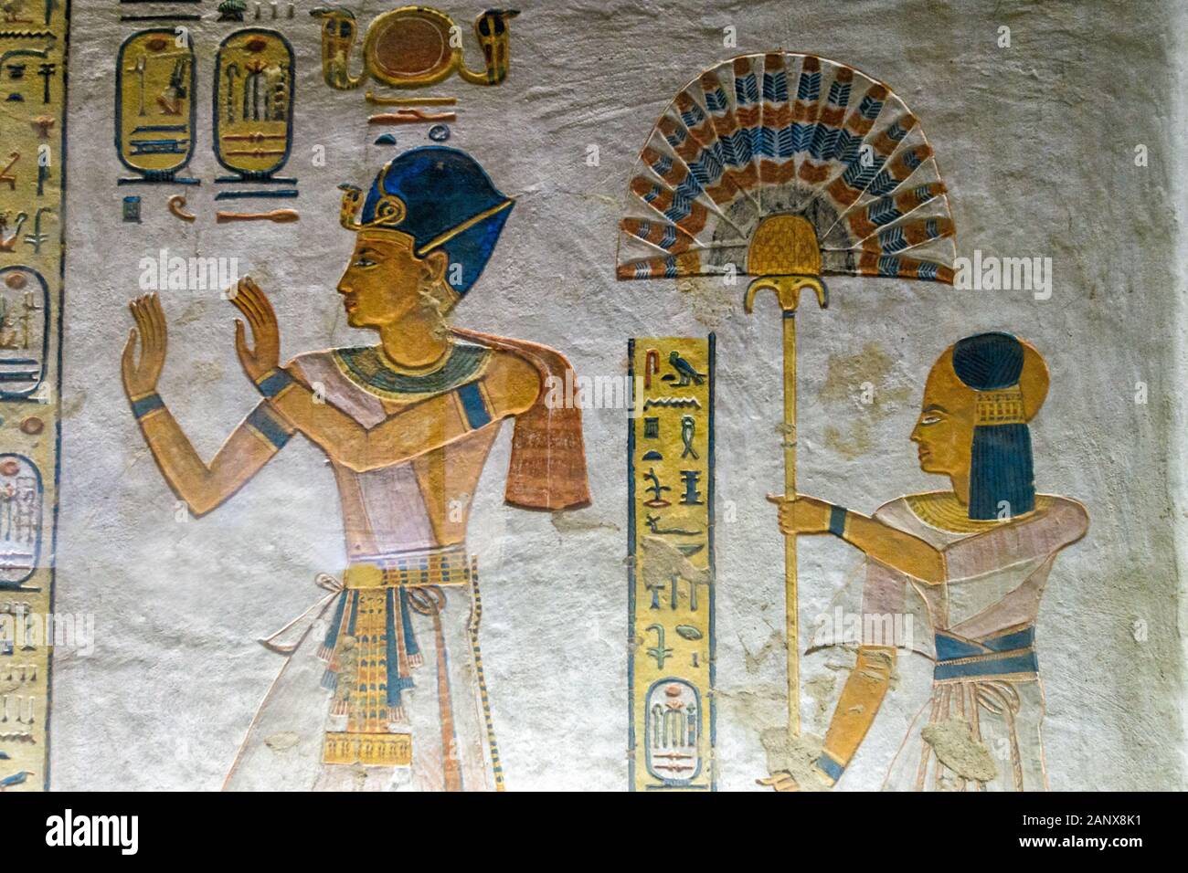 El príncipe Khaemwaset lleva el colorido behet-fan en ambas manos junto a su padre, Ramsés III, la columna jeroglífica amarilla muestra su nombre Foto de stock