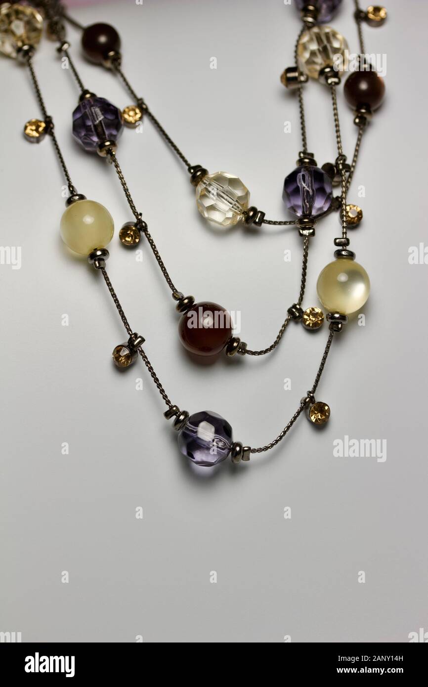 Vista de cerca de un colorido collar bisutería abalorios de cristal sobre fondo neutro con espacio de copia Fotografía de stock - Alamy