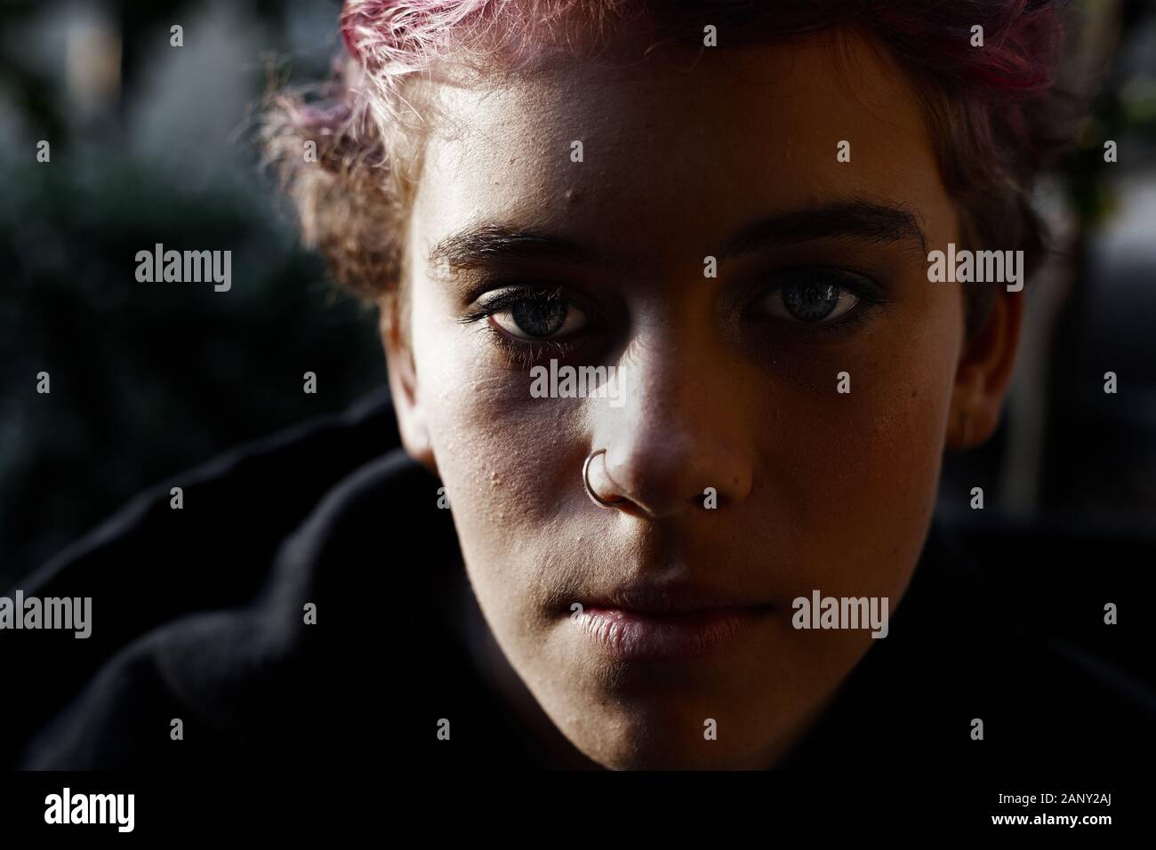 Retrato de la depresión adolescente con pelo corto en la oscuridad, Moody luz Foto de stock