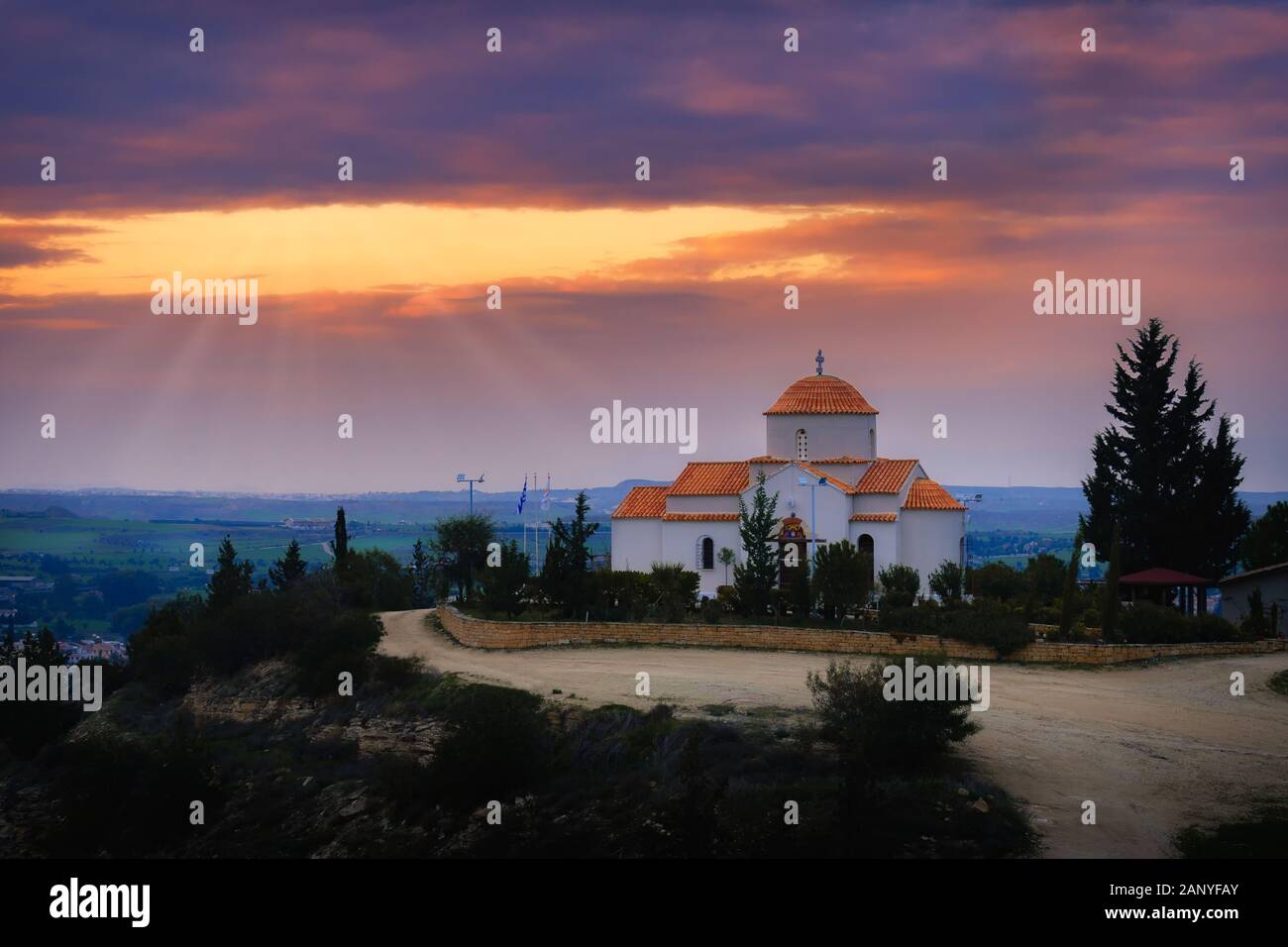 Panagia Tsampika Iglesia ortodoxa en la cima de una colina en el distrito de Nicosia, Chipre en una puesta de sol con rayos de luz Foto de stock