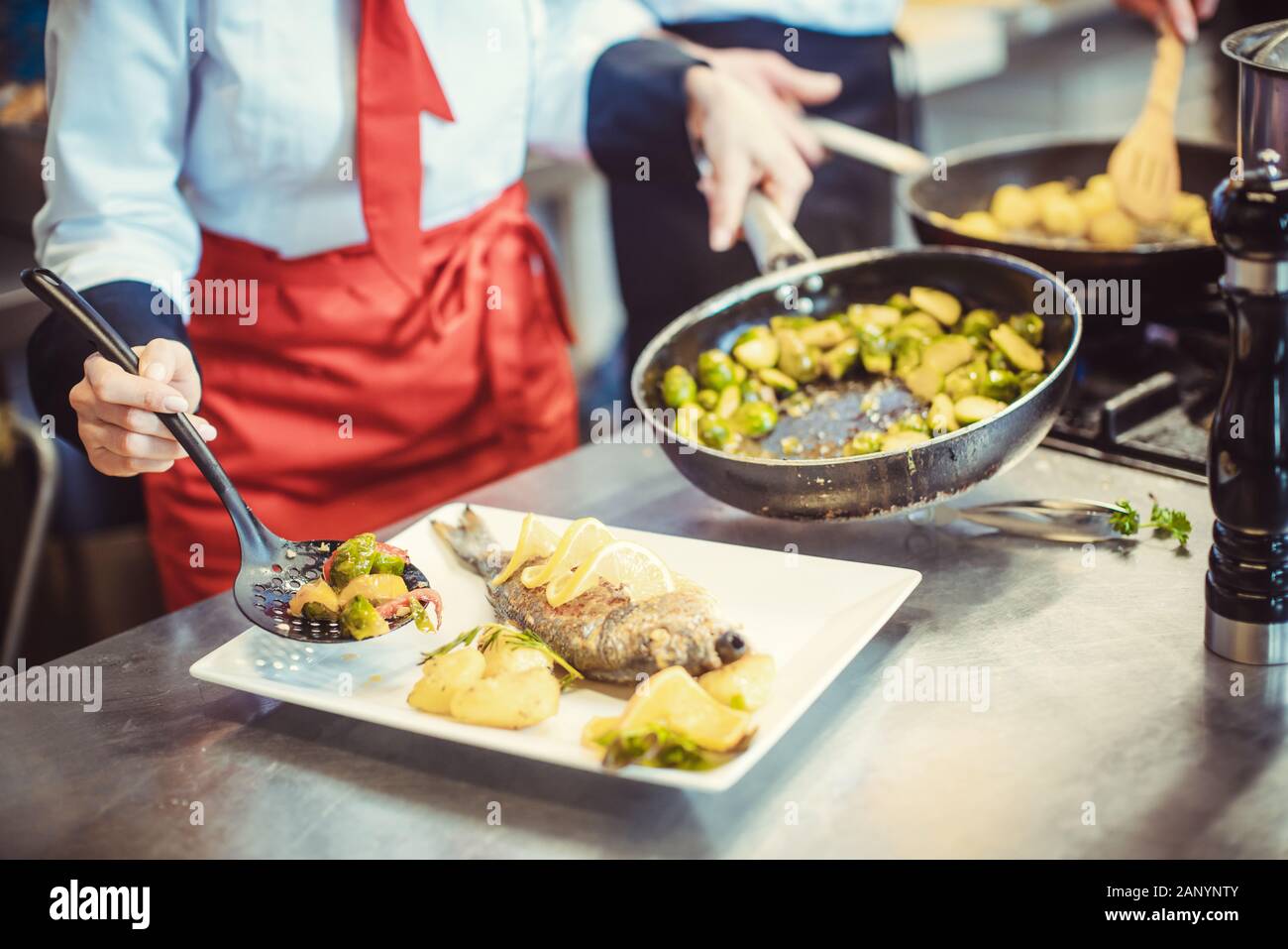 Jefe de cocina en el restaurante poner comida en un plato pronto para