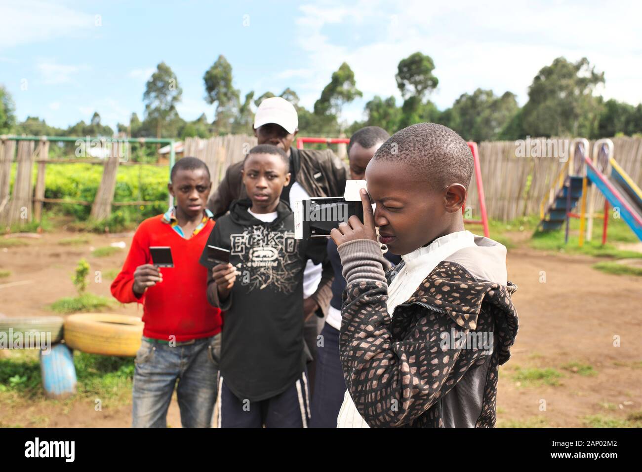 Una joven ugandesa Chica del este de África tiene una cámara instantánea mientras aprende fotografía en el campo rural Foto de stock