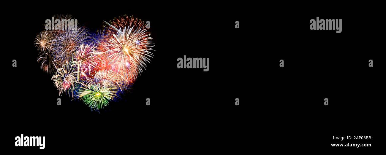 Coloridos fuegos artificiales en la forma de un corazón panorámica sobre fondo negro. Día de San Valentín banner web. Foto de stock