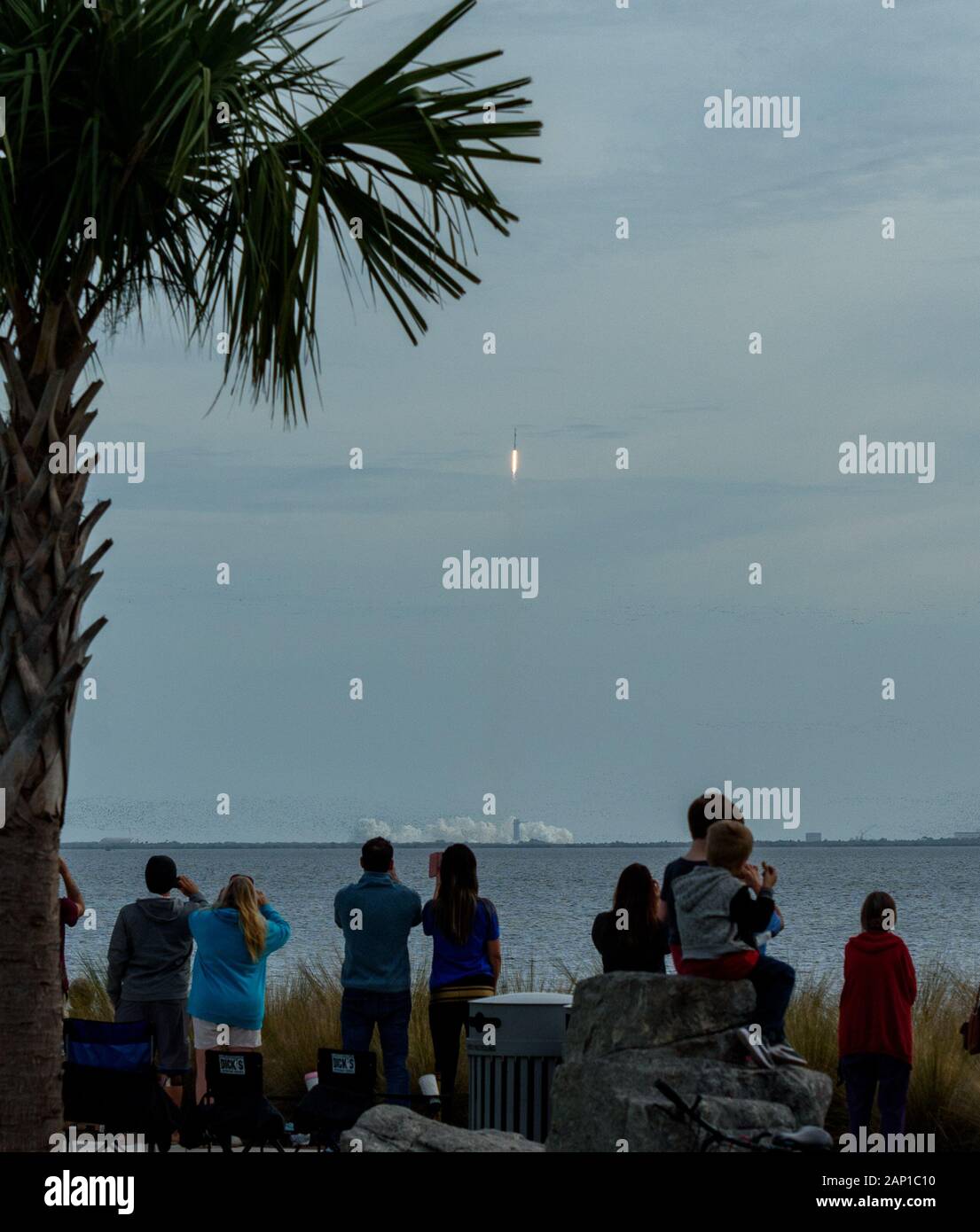 La gente mira desde Titusville, Florida como un cohete SpaceX Falcon 9 que lleva la cápsula del astronauta Crew Dragon para una prueba en Cabo Cañaveral. Foto de stock