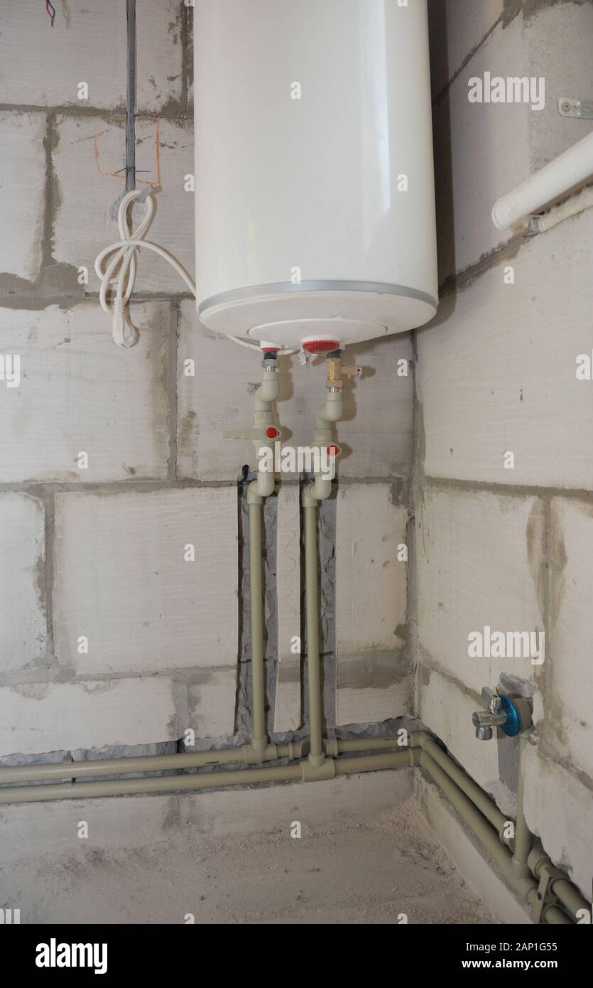 Instalación y ocultar en tubos de pared de agua en la casa de baño con  calentador eléctrico. Groove o zanja para cortar los tubos de agua en la  pared Fotografía de stock -