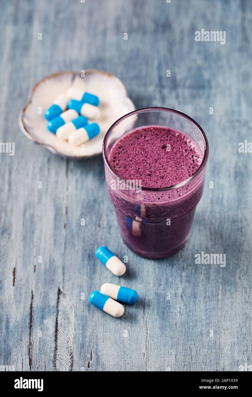 Vaso de batido de proteínas con leche y arándanos y cápsulas de creatina.  Concepto de nutricion Fotografía de stock - Alamy