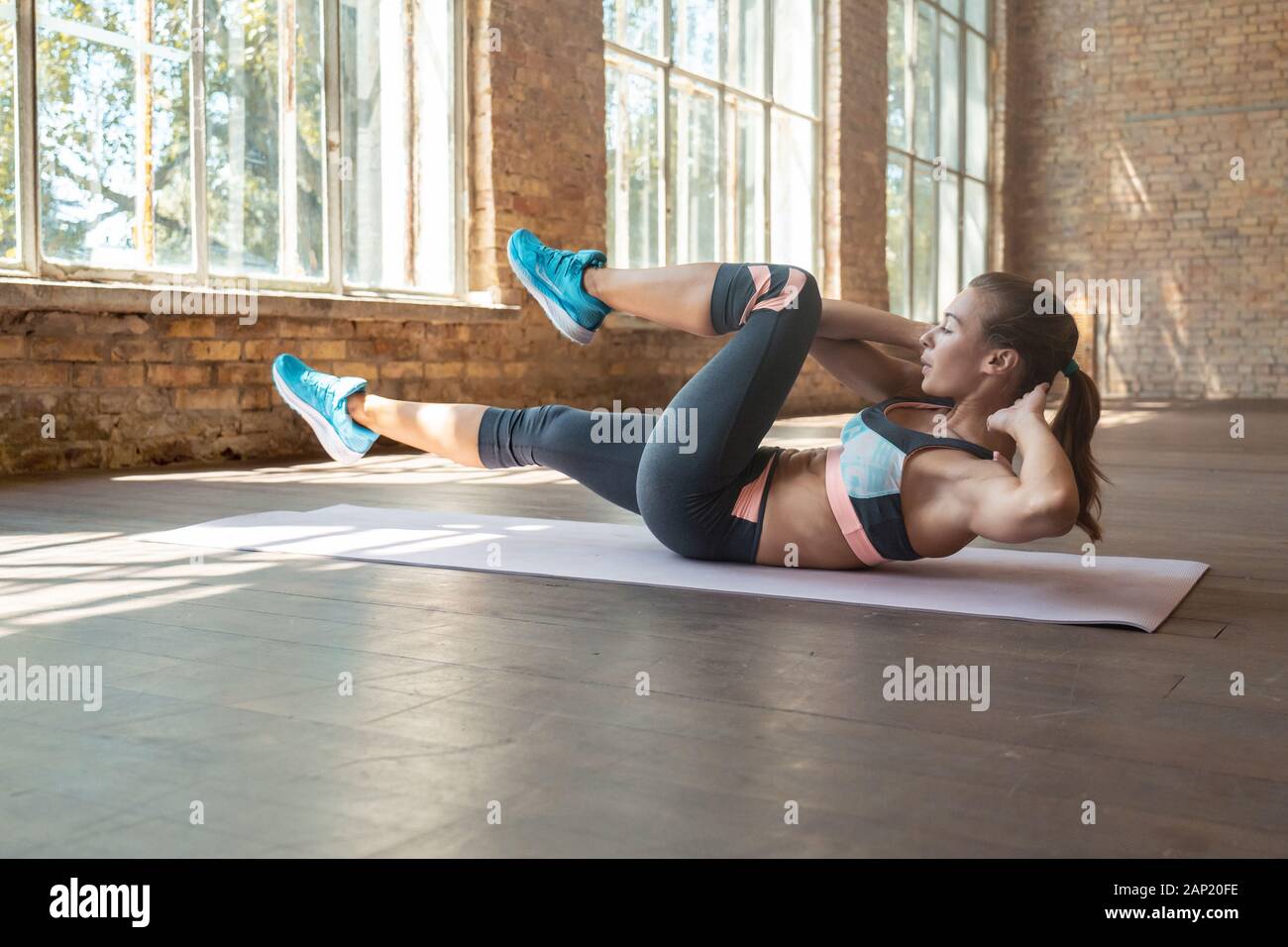 Colocar deportivo joven haciendo bicicleta crunch ejercicio acostado en el  piso de MAT en el gimnasio Fotografía de stock - Alamy