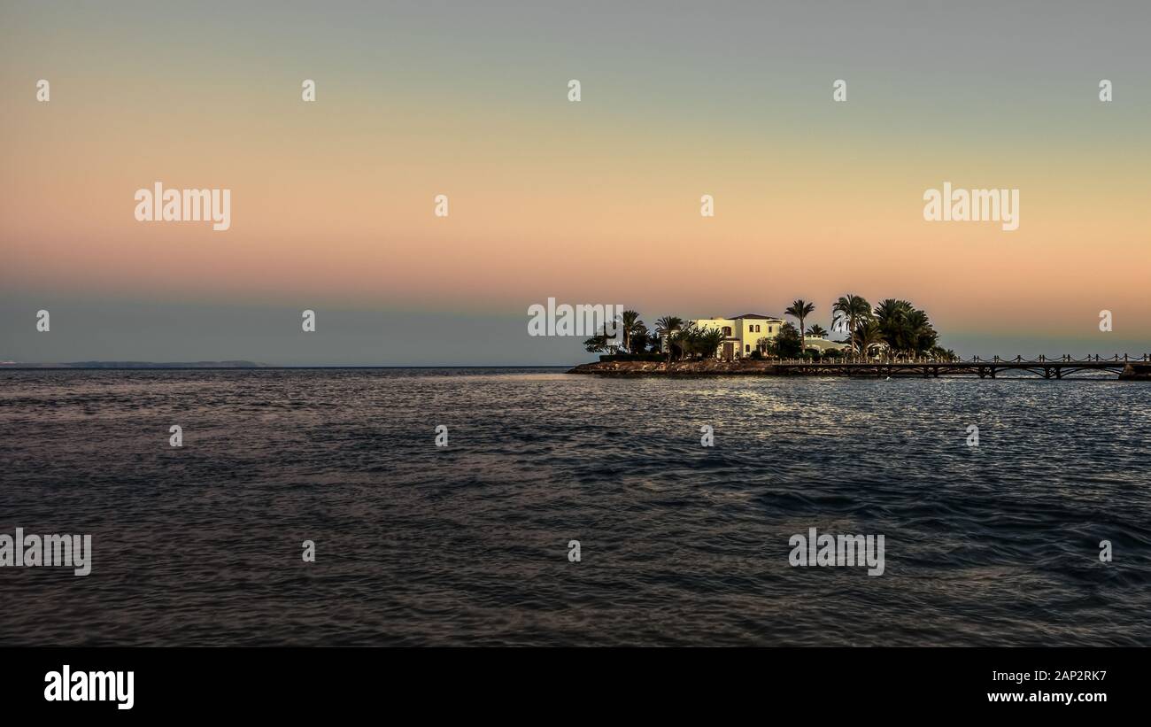 Villa Blanca en una pequeña isla con palmeras y un puente en el crepúsculo luz del atardecer, el Guna, Egipto, 07 de enero de 2020 Foto de stock