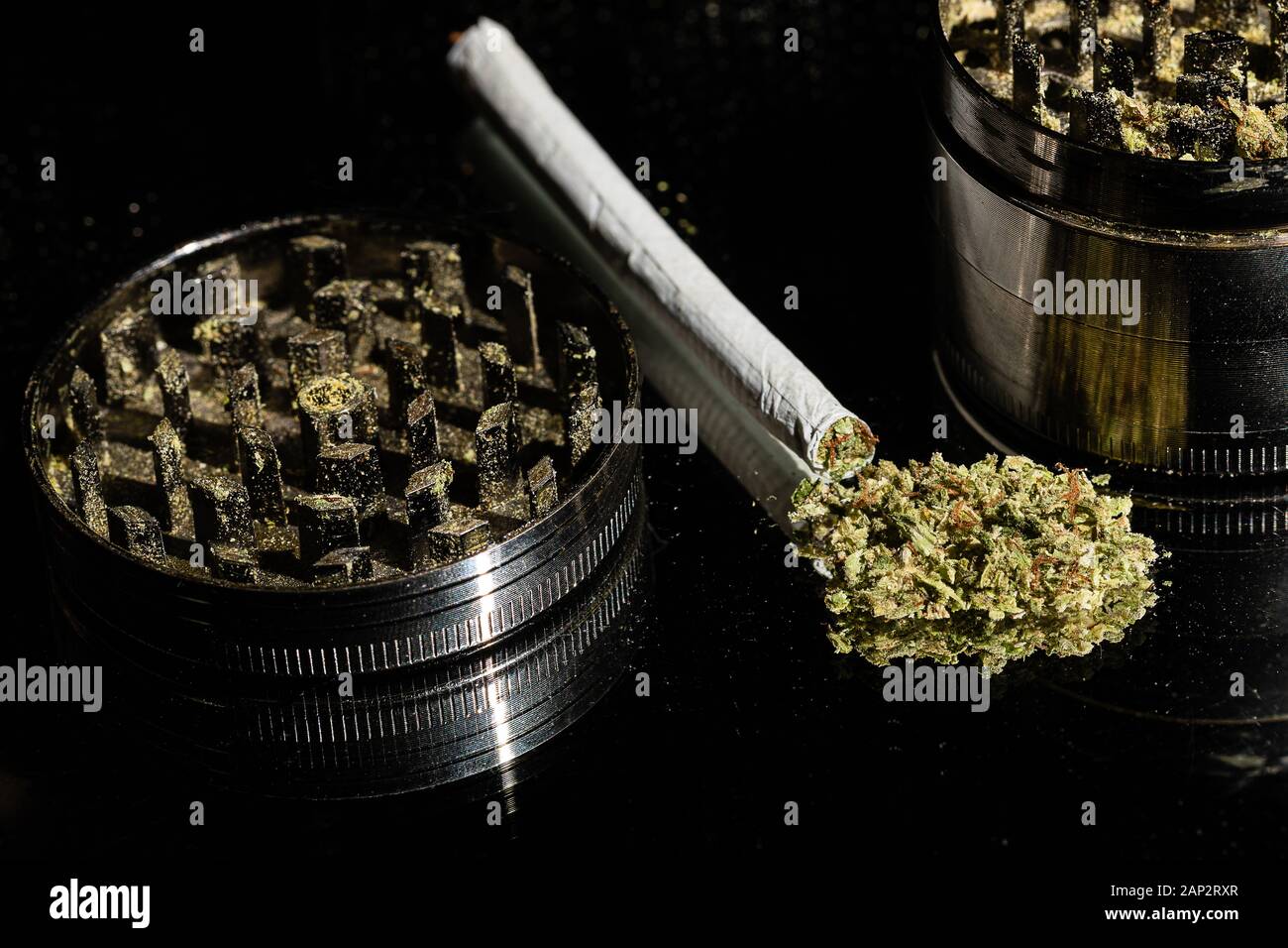 Un molinillo de especias se utiliza a menudo para preparar la marihuana para rodar en una articulación o fumar en una pipa o recipiente. Un conjunto liados a mano con una amoladora y un montón Foto de stock