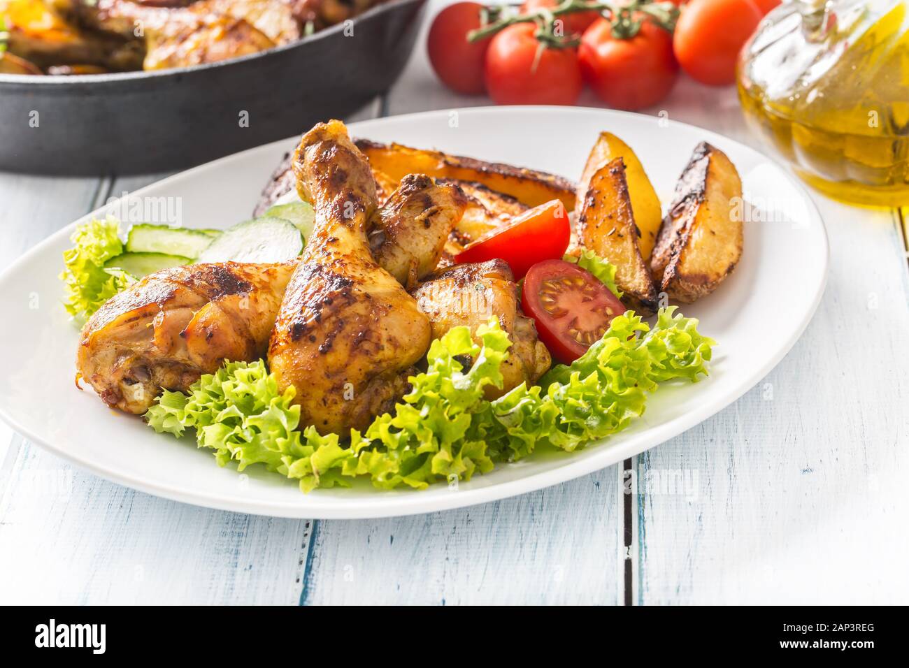 Piernas de pollo asado con ensalada de lechuga y tomate Fotografía de stock  - Alamy