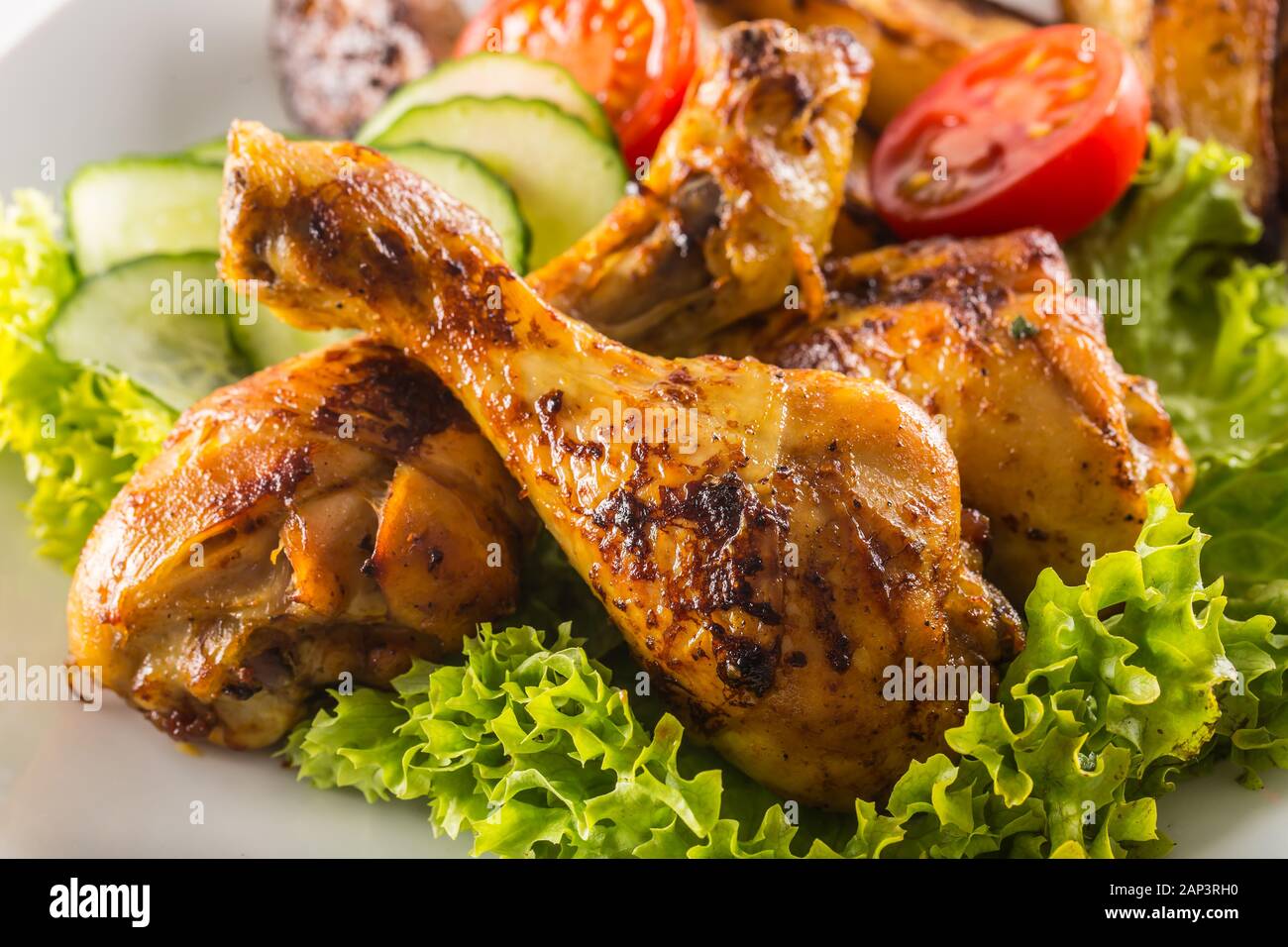 Piernas de pollo asado con ensalada de lechuga y tomate Fotografía de stock  - Alamy