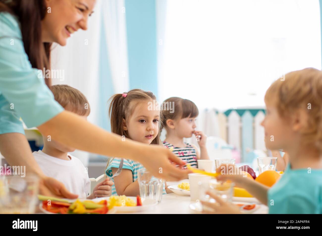 Grupo de niños de kindergarten tienen almuerzo en guardería Foto de stock