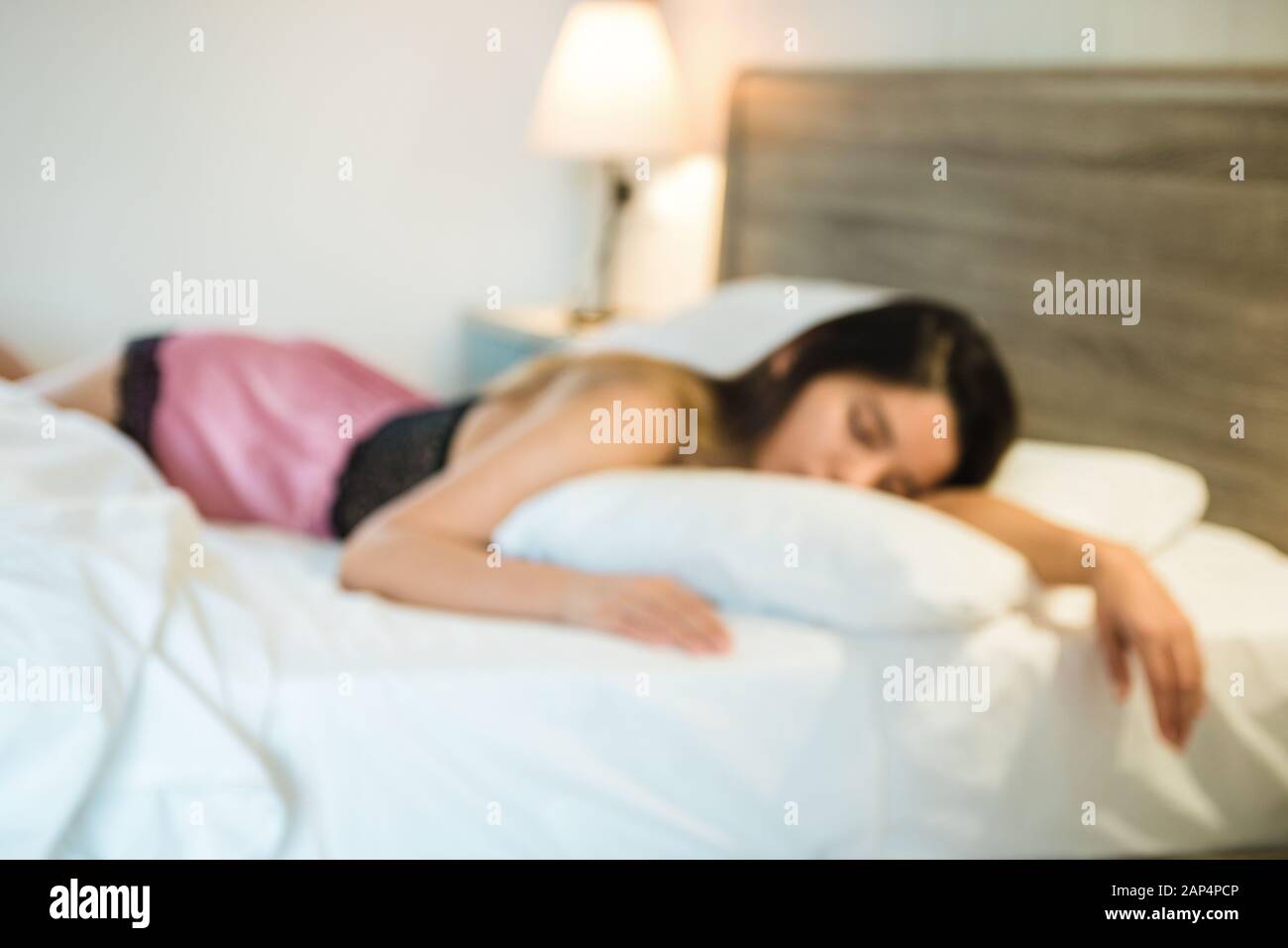 mujer durmiendo en la cama fuera de foco Foto de stock