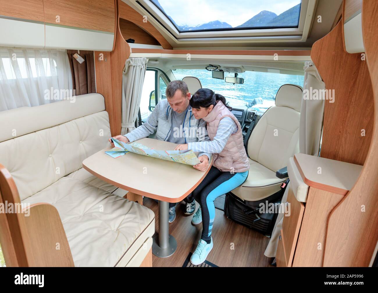 Las parejas en RV Camper mirando el mapa local para el viaje. Viajes de vacaciones familiares, viaje de vacaciones en autocaravana, caravana alquiler de vacaciones. Foto de stock