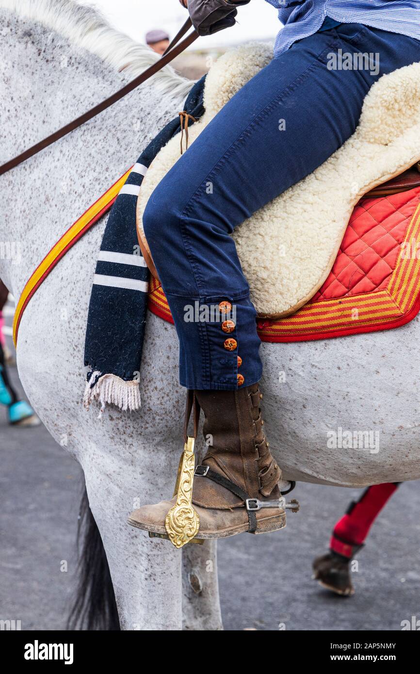 Detalle de jinete de pierna en atuendo de moda con el botón Detalle en la pernera  del pantalón y estribo adornados de latón pulido en la fiesta de San  Sebastián en La