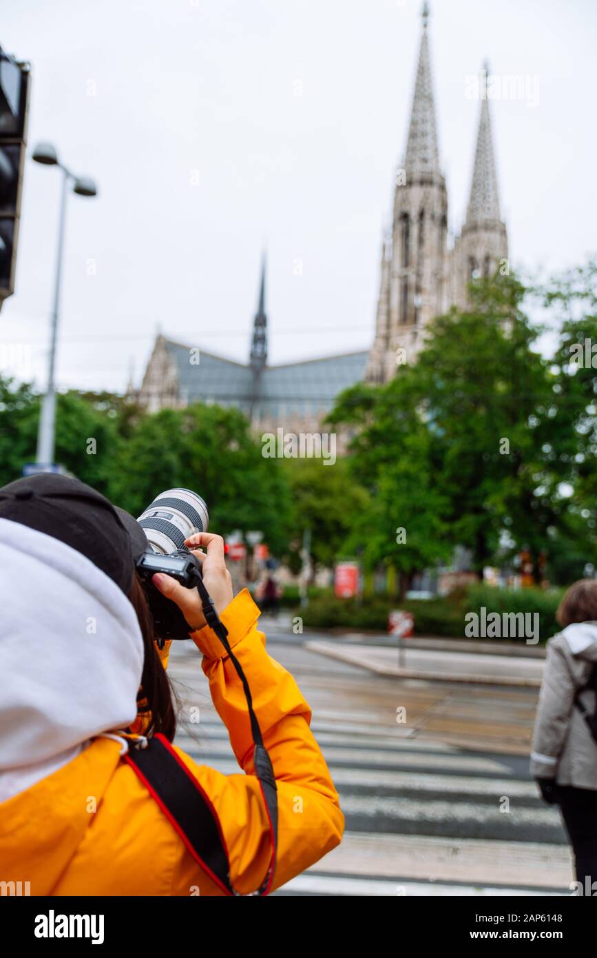 mujer con cámara profesional tomando la foto de la antigua iglesia gótica Foto de stock