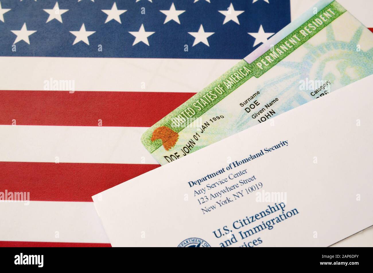 Tarjeta verde residente permanente de los Estados Unidos de DV-lotería se  encuentra en la bandera de los Estados Unidos con el sobre del Departamento  de Seguridad Nacional de cerca Fotografía de stock -