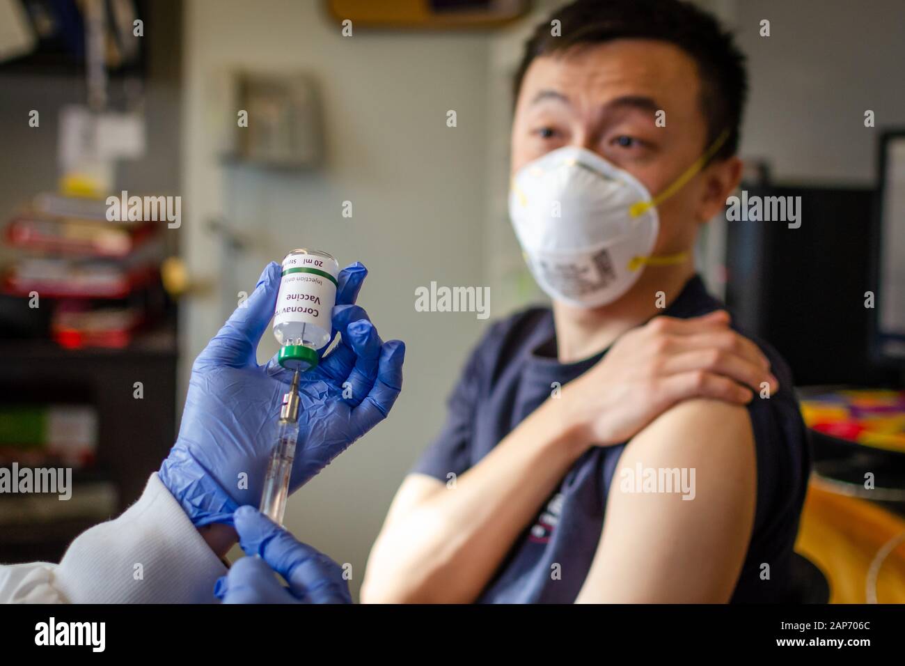 El varón chino que recibe la vacuna contra el coronavirus en la clínica de salud Foto de stock