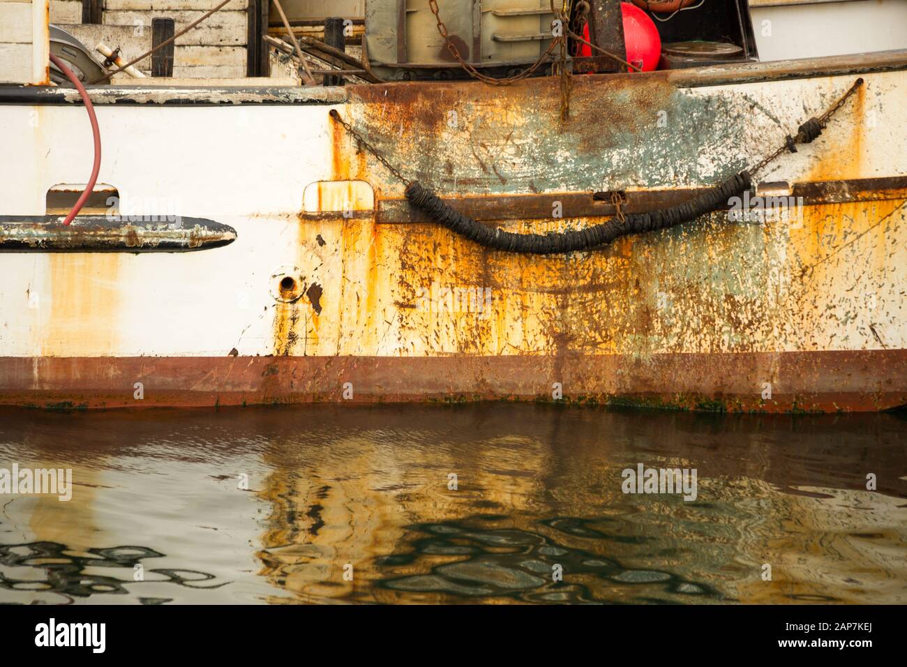 Antiguo barco de pesca oxidado esperando en el puerto. Foto de stock