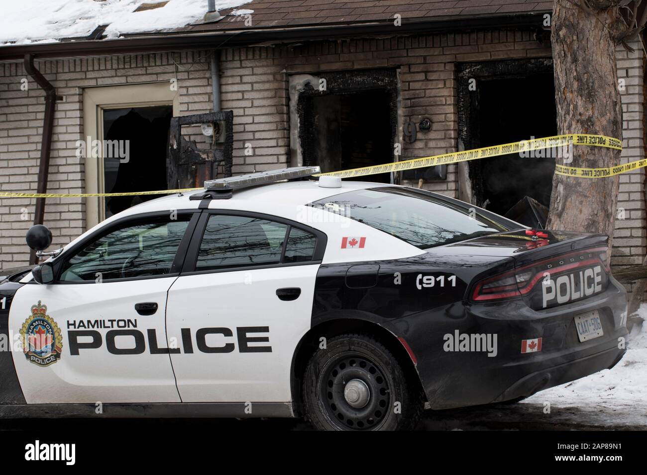 Ontario, Canadá 2020:Investigación de incendios en curso incendiario escena del crimen con coche de policía y cinta amarilla. Casa residencial muy dañada destruida por f Foto de stock