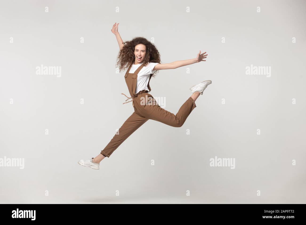 Feliz señorita volando, saltando con las manos elevadas. Foto de stock