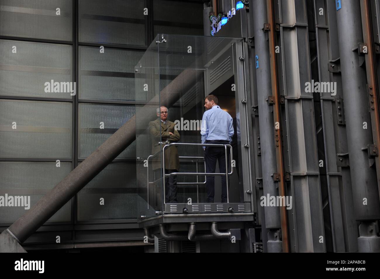 La gente monta en los ascensores en el edificio Lloyd's de Londres en Lime Street, Londres, Inglaterra Foto de stock