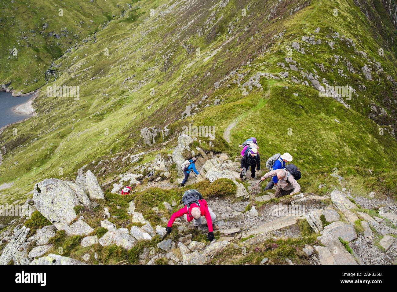 Excursionistas subiendo por la montaña Pen yr Helgi Du desde el embalse Ffynnon Llugwy en las montañas Carneddau del Parque Nacional de Snowdonia. Ogwen, Gales Del Norte, Reino Unido Foto de stock