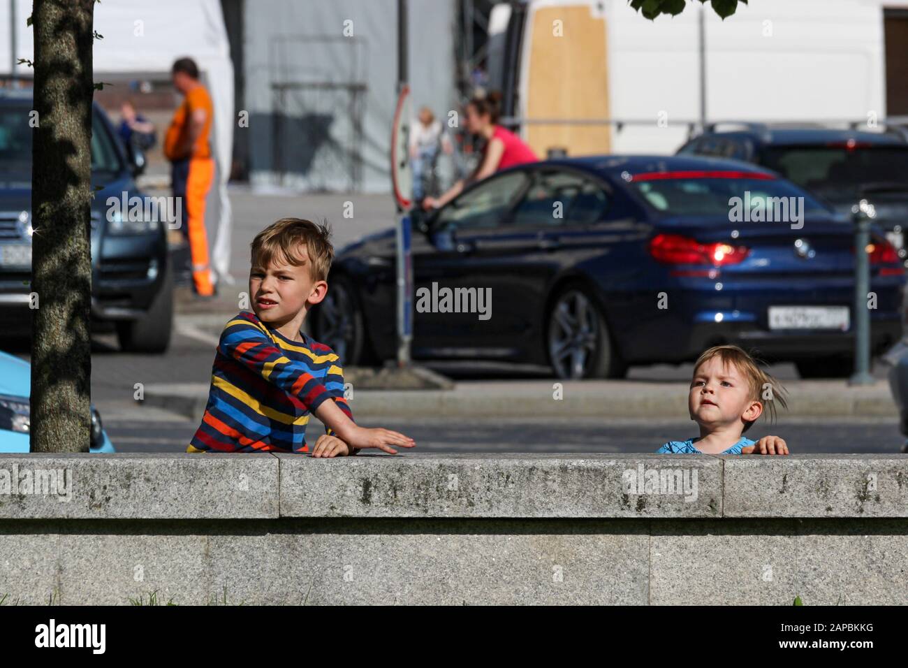 Niños pequeños detrás de una valla de piedra en Vilnius, Lituania Foto de stock