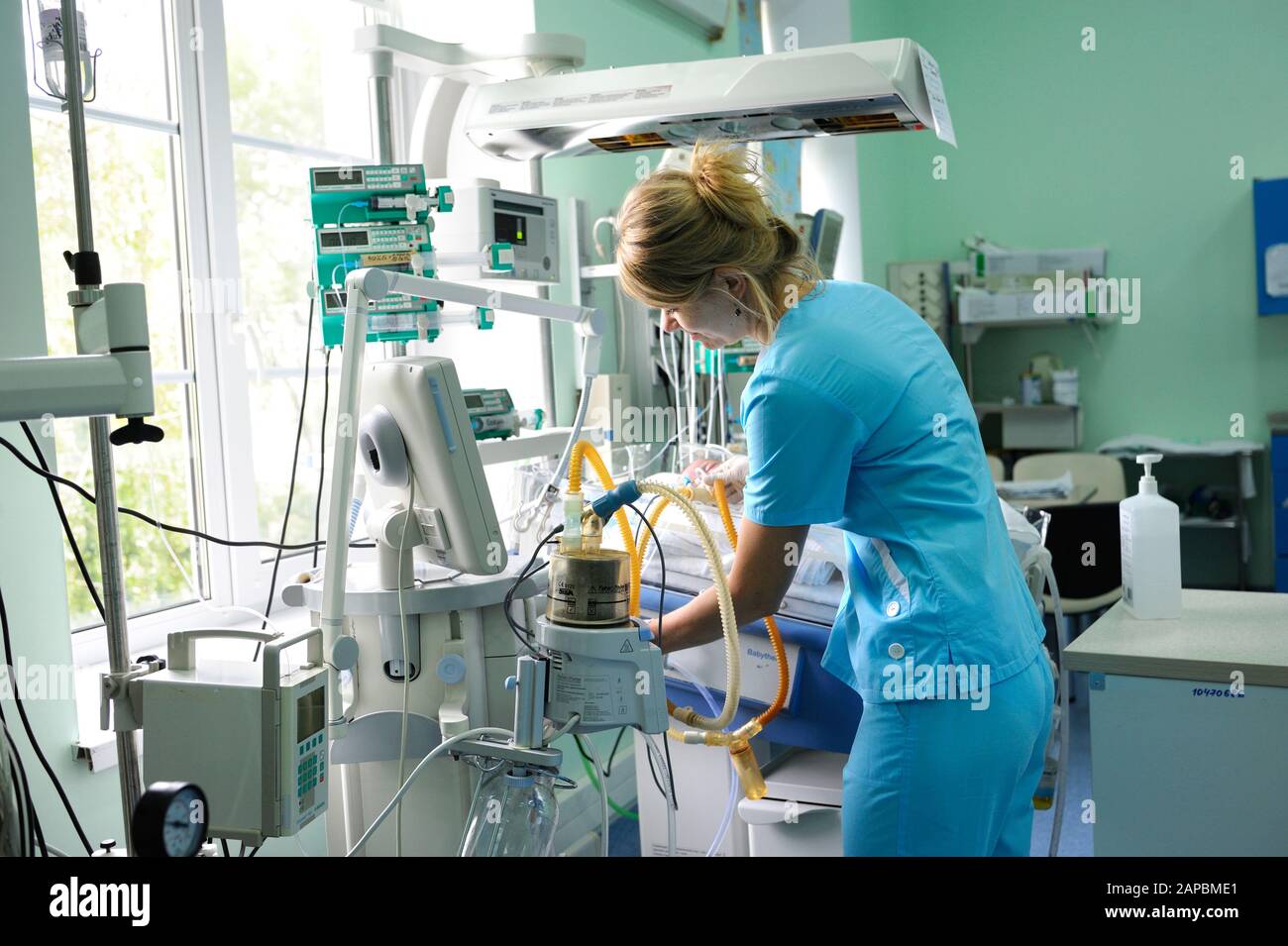 En la unidad de cuidados intensivos. Enfermera parada cerca de la cama del hospital con el bebé preparándolo para el tratamiento. Centro Cardíaco Para Niños.Mayo De 18,2018. Kiev, Ucrania Foto de stock